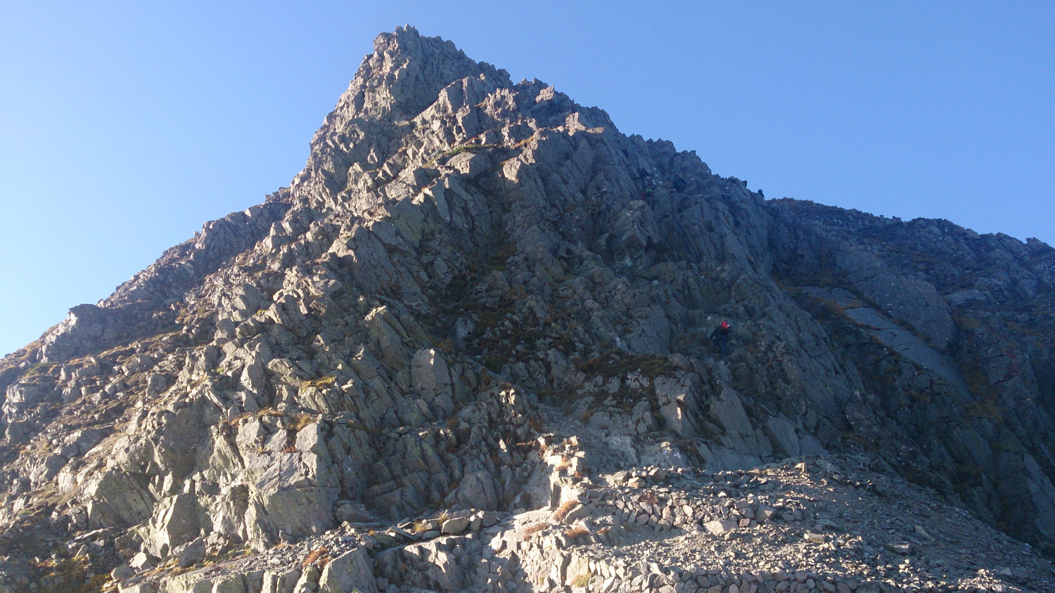 穂高岳山荘から奥穂高方面を見上げる、山荘直上の鎖場に登山者が多数見える