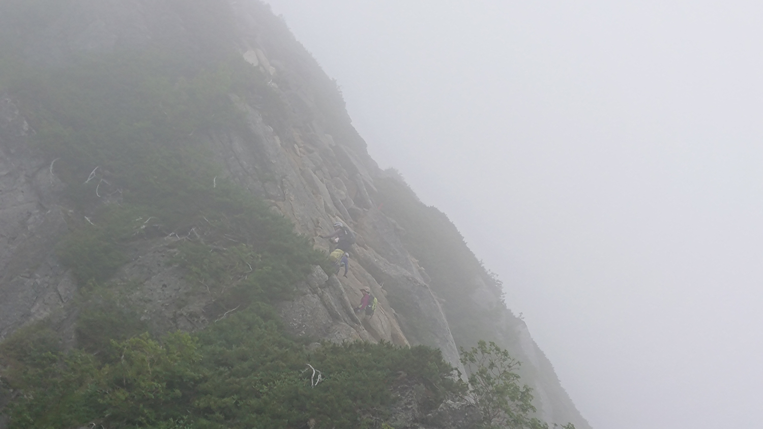 岩の斜面に着く登山道、ガスが濃い